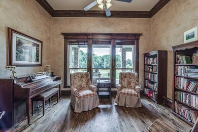 Study has dark wood trim and a view to the back pa