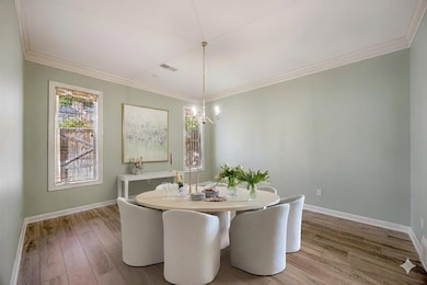 Dining area featuring light wood-style floors and ornamental molding