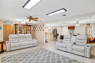 Living area with ceiling fan and light tile patterned floors