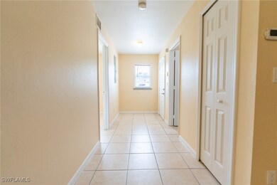 Hallway with light tile patterned floors and baseb