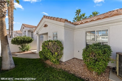 View of side of property featuring a tiled roof and stucco siding