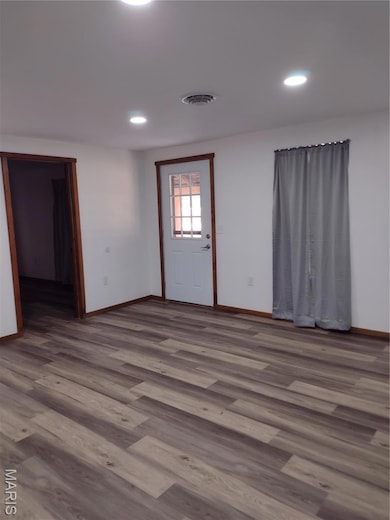 Unfurnished room with wood finished floors and recessed lighting