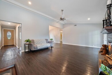 Living room featuring crown molding, ceiling fan,