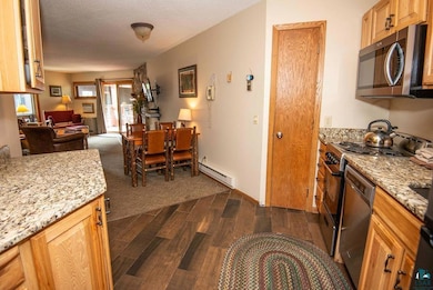 Kitchen featuring a textured ceiling, a baseboard 