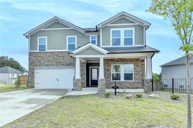 Craftsman house featuring stone siding, a front ya