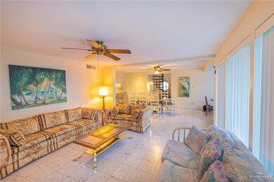Living room with light tile floors, beam ceiling, and ceiling fan