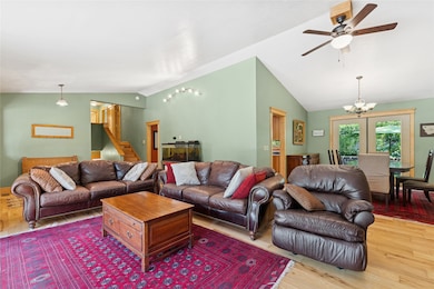 Living area with a vaulted ceiling is open to the dining area