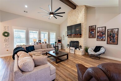 Living room with a stone fireplace, ceiling fan, b