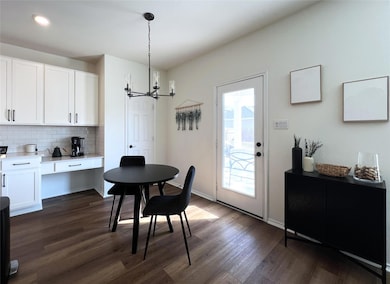 Dining space featuring a chandelier and dark wood-style flooring