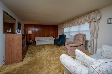 Large living room featuring wall to wall carpeting