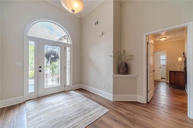 Foyer with ornamental molding, plenty of natural l