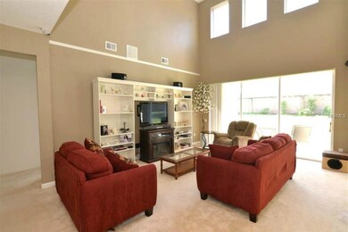 Great room has electric fireplace and tons of natural light. Triple slider opens to covered lanai.