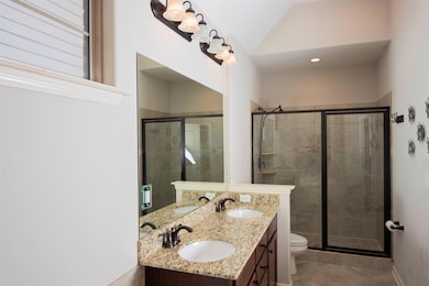 Bathroom featuring lofted ceiling, double sink van