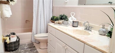 Full bathroom featuring tile walls, vanity, toilet