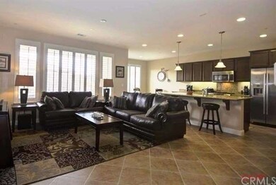 Open, tiled living space opens to kitchen.