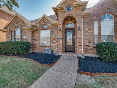 Property entrance with brick siding and a beautiful solid iron front door