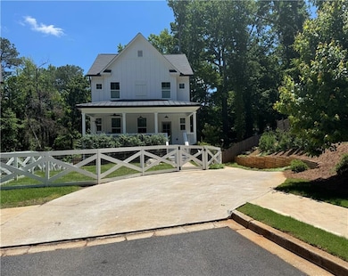 Modern farmhouse style home with board and batten siding, covered porch, a standing seam roof, and metal roof