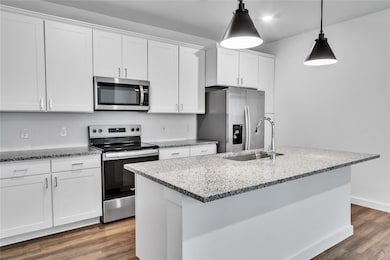 Kitchen featuring dark wood finished floors, stain