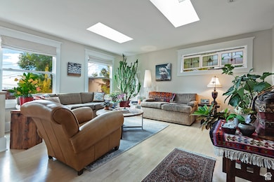 Living area with wood finished floors and a skylight