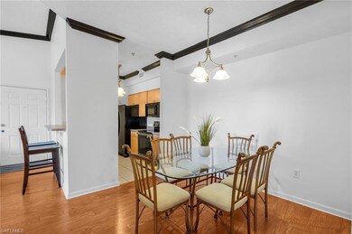 Dining space with crown molding, a chandelier, and light wood-style flooring