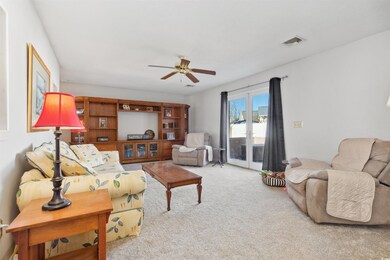 Living area featuring a ceiling fan, light colored
