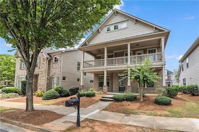 View of front of house with a balcony, covered porch, and brick siding