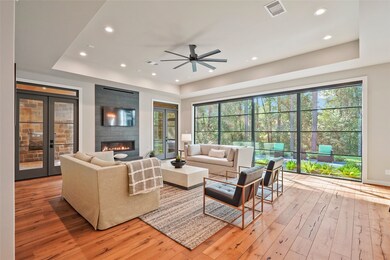 LIVING ROOM  PHENOMENAL DIMENSIONS with a back wall of glass & 2 sets of French doors out to the Screened Porch.  Imagine the flexibility for 2 sofas and plenty of room to spare. 24 feet of glass showcase the majestic trees & native plantings.