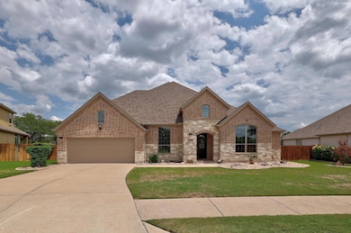French country home featuring brick siding, drive