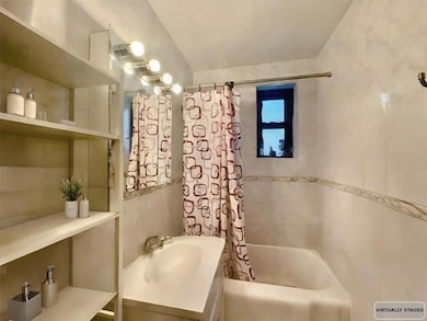 Bathroom featuring vanity and shower / bathtub combination with curtain