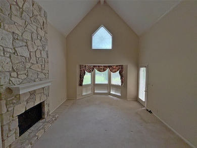 Unfurnished living room featuring a stone firepla