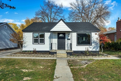 Bungalow with a front yard and a shingled roof