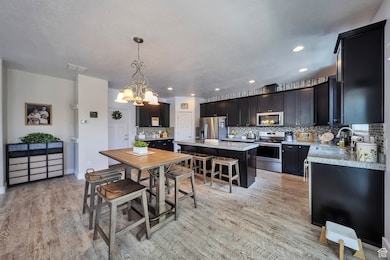 Dining area featuring a chandelier, light wood-style flooring, and recessed lighting