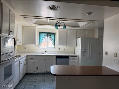 Kitchen with white fridge with ice dispenser, wall
