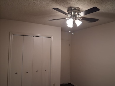 Unfurnished bedroom featuring a textured ceiling, a ceiling fan, and a closet