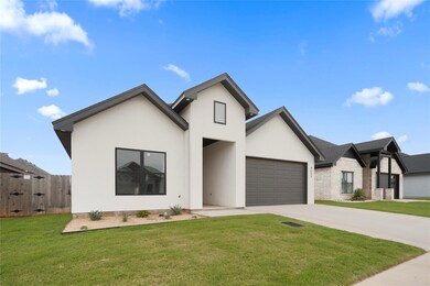 View of front of house with a garage and a front y