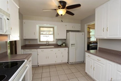 Kitchen with corian, tile flooring, lots of cabine