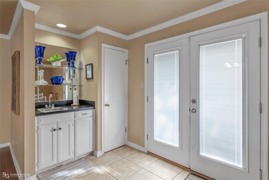 Entryway featuring sink, french doors, crown moldi