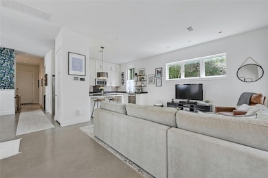 Living area featuring baseboards, finished concre