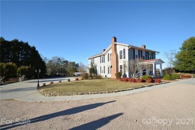Curved gravel and concrete driveways lead you to t