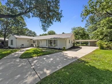 Single story home with a front yard and a carport
