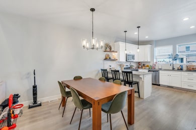 Dining area featuring light wood-style flooring, recessed lighting, and a chandelier