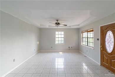 Tiled entryway with plenty of natural light, a raised ceiling, and ceiling fan