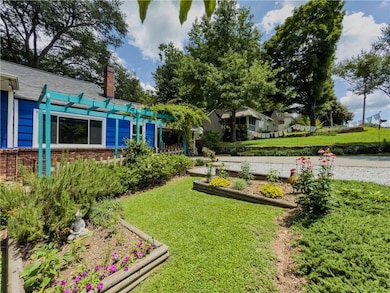 View of grassy yard with a pergola and a garden