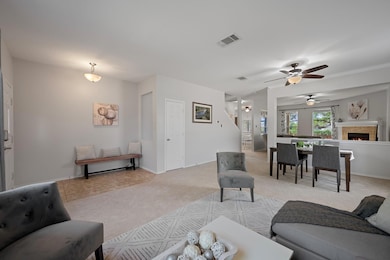 Living room with light carpet, a ceiling fan, bas