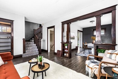 Living room with decorative columns and dark hardw