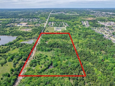 View of property location with property parcel outlined, a nearby body of water, and a heavily wooded area