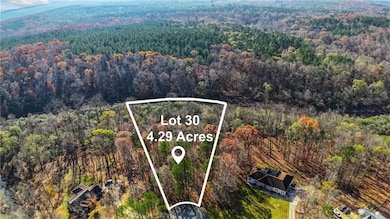 Aerial view of property and surrounding area with property parcel outlined and a heavily wooded area