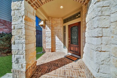 A secluded cove style covered entry welcomes you home, providing privacy and shelter while highlighting the beautiful brick and stone work on the home.