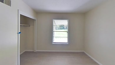 Unfurnished bedroom featuring light wood-type flooring, baseboards, and a closet
