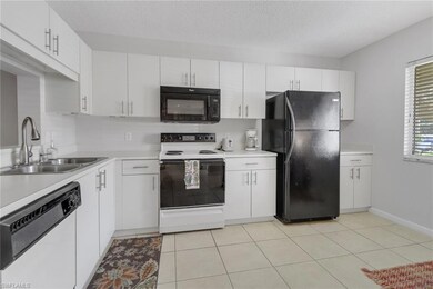 Kitchen with electric range, white cabinetry, and 